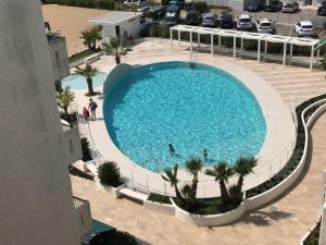 an overhead view of a large swimming pool with palm trees at Residence El Palmar DA COLLA in Lido di Jesolo