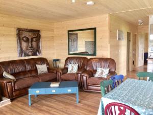 a living room with leather couches and a table at Lakeside Fishing Lodges in Boston