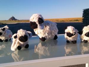 a group of stuffed sheep standing on a ledge at La Jacotière in Ardevon