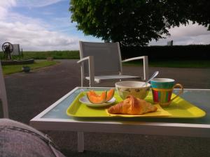 a tray with a plate of orange slices and a cup of coffee at La Jacotière in Ardevon