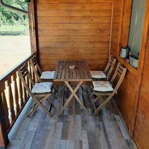 einen Holztisch und Stühle auf einer Veranda in der Unterkunft Apartman Šumska Tajna in Mokra Gora