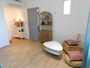 uma sala de estar com uma mesa branca e cadeiras em La Maison de Paul & Margaux em Châteauneuf-de-Galaure