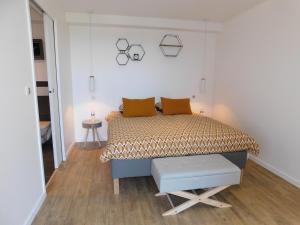um quarto com uma cama com almofadas laranja em La Maison de Paul & Margaux em Châteauneuf-de-Galaure