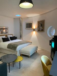 a bedroom with a bed and a table and a tv at LA MAISON DE ROBINSON in Le Plessis-Robinson