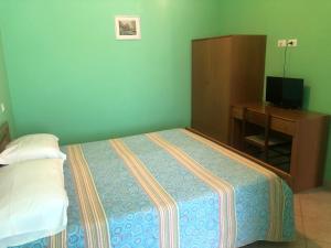 una camera con letto, armadio e TV di Il Portichetto a L'Aquila