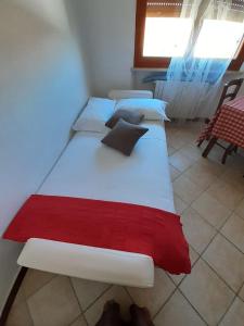 een slaapkamer met 3 bedden en rode en witte kussens bij la terrazza del silenzio in Fattoria Spedaletto