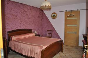 a bedroom with a bed with a pink wall at Chambres d'Hotes La Mouline in Ludon-Médoc