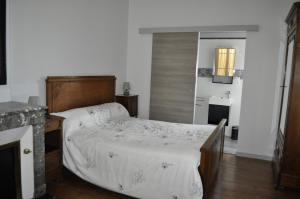 a bedroom with a bed with a wooden head board at Chambres d'Hotes La Mouline in Ludon-Médoc