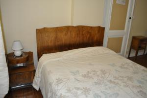 1 cama con cabecero de madera en un dormitorio en Chambres d'Hotes La Mouline, en Ludon-Médoc