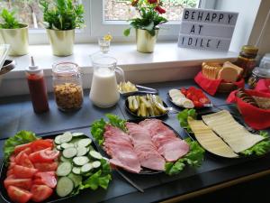 uma bandeja de comida com carnes e queijo no balcão em Idilė Bed & Breakfast - Visaginas em Visaginas