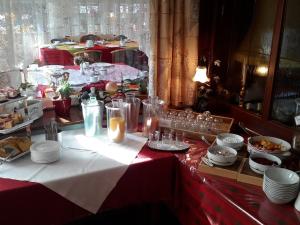 a table with plates and glasses on top of it at Landgasthof Kleine Kommode in Zorge