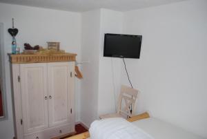 ein Wohnzimmer mit einem TV an der Wand in der Unterkunft Landgasthof Hirschen Untermettingen in Ühlingen-Birkendorf