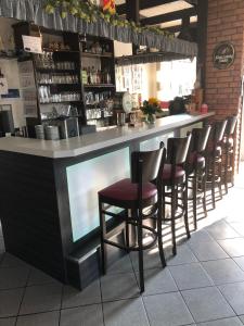 a bar with a row of stools in a restaurant at Landgasthof Rheda Hotel - Restaurant in Rheda-Wiedenbrück