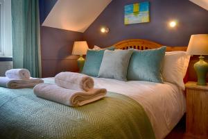 a bedroom with a bed with towels on it at The Lansdowne Cottage in Bourton on the Water