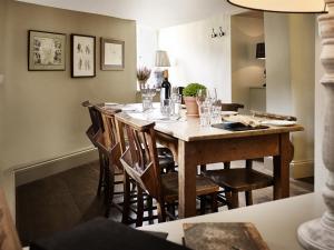 a dining room with a wooden table and chairs at The Masons Arms in Cirencester