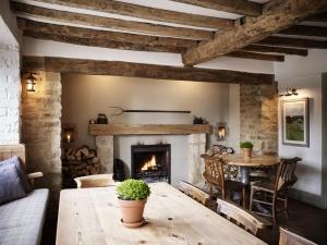 een woonkamer met een open haard en een tafel bij The Masons Arms in Cirencester