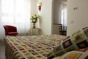 a bedroom with a bed and a vase of flowers at Hotel O'scià in Lampedusa