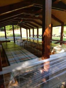 eine Person, die in einem Pavillon mit Tischen und Bänken wandelt in der Unterkunft Brunarica in Globoko