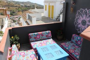 uma varanda com cadeiras e vista para a cidade em La posada del Cani em Cómpeta