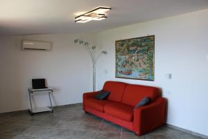 Casa Vacanze Chery في سورينتو: أريكة حمراء في غرفة المعيشة مع مصباح