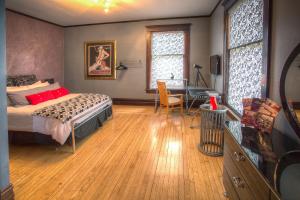 een slaapkamer met een bed en een bureau bij Lauerman House Inn Bed & Breakfast in Marinette