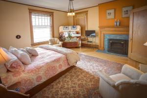 een slaapkamer met een bed en een open haard bij Lauerman House Inn Bed & Breakfast in Marinette