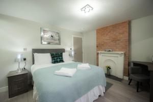 een slaapkamer met een groot bed en een open haard bij Laurel House in Reading