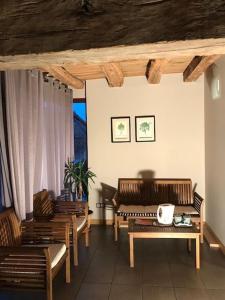 a living room with wooden benches and a table at Hameau des Damayots in Montbeugny