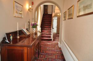 a hallway with a stairway with a desk and a staircase at Lower Bryanston Farm in Blandford Forum