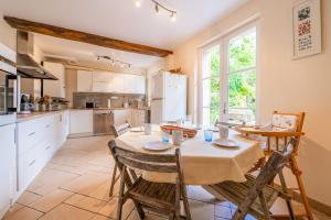 una cucina e una sala da pranzo con tavolo e sedie di Le Colombier - Fairytale Factory a Montgeroult