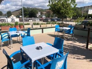 a group of tables and blue chairs on a patio at Il Portichetto in LʼAquila