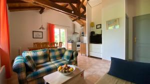 ein Wohnzimmer mit einem Sofa und einer Obstschale auf einem Tisch in der Unterkunft Les Hauts du Coustalier in Doissat