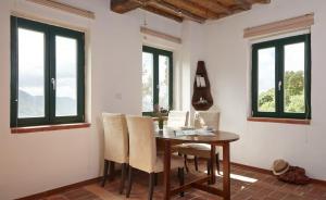 uma sala de jantar com mesa, cadeiras e janelas em Casa Berti - Urlaub im Olivenhain em Camaiore