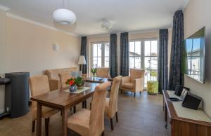 a living room with a dining room table and chairs at Villa Ostsee in Göhren