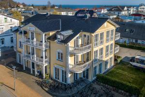 une vue sur une grande maison jaune dans l'établissement Villa Ostsee, à Göhren