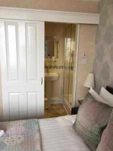 a bedroom with a bed and a bathroom with a shower at The Leeway in Scarborough