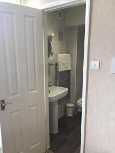 La salle de bains blanche est pourvue d'un lavabo et de toilettes. dans l'établissement The Leeway, à Scarborough