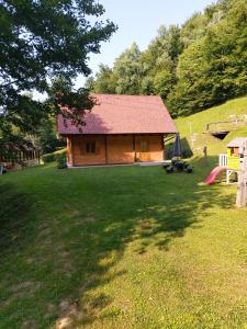 eine kleine Hütte mit rotem Dach im Hof in der Unterkunft Brunarica in Globoko