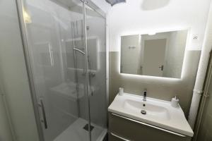 La salle de bains est pourvue d'un lavabo et d'une douche en verre. dans l'établissement Domaine du parc, à Grandvillers