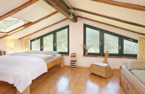 1 dormitorio con 2 camas y ventanas grandes en Casa Berti - Urlaub im Olivenhain en Camaiore