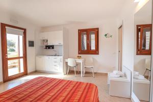 ein Schlafzimmer mit einem Bett und einem Tisch sowie eine Küche in der Unterkunft Casette D'amore in Lampedusa