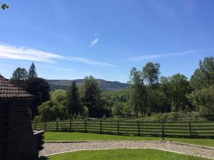 a fence with a view of the hills in the distance at Leny Estate in Callander