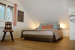 a bedroom with a bed and a chair and a window at Le Clot de la Hount in Cauterets