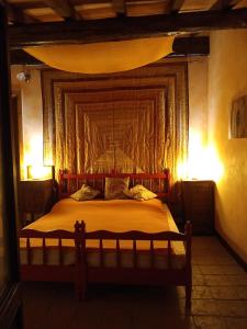 a bedroom with a bed with a large headboard at Bed and Breakfast Balli coi Lupi in Varzi