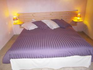 a large purple bed in a bedroom with two lamps at Le Péché de Paresse in Saint-André-en-Vivarais