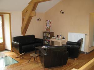 a living room with black leather chairs and a table at Le Péché de Paresse in Saint-André-en-Vivarais