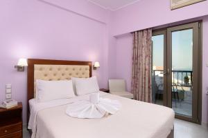 a bedroom with a white bed with a bow on it at Avra in Agia Galini