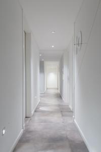 an empty corridor in an office building with white walls at Ciudad Prado Hotel in Cordoba