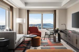 Four Seasons Hotel San Francisco at Embarcadero في سان فرانسيسكو: غرفة معيشة بها أريكة وكراسي ونافذة كبيرة