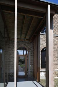 uma entrada para um edifício de tijolos com uma porta de vidro em Le Presbytère em Hermalle-sous-Huy